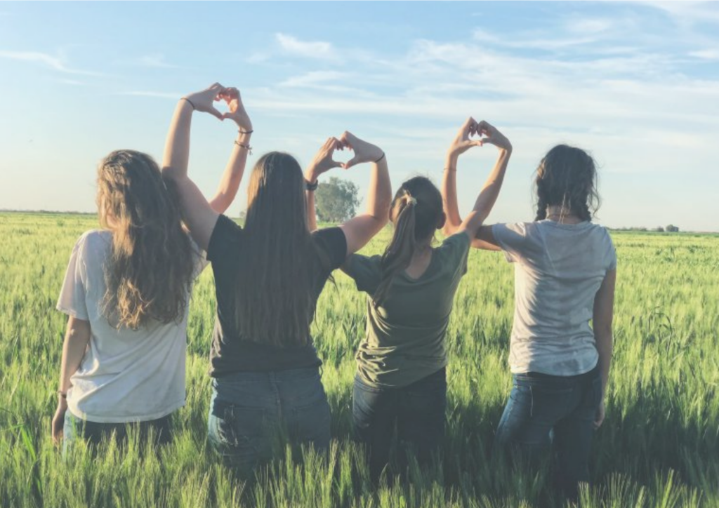 Tytöt pellolla näyttävät sydämiä